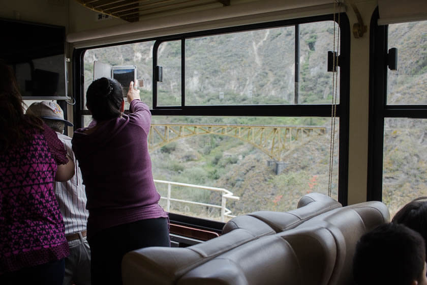 A woman taking photos of the view from aboard the Tren de la Libertad in Ecuador.