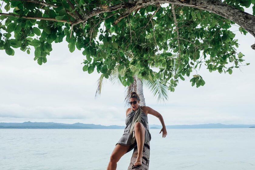 Woman trying to climb a palm tree